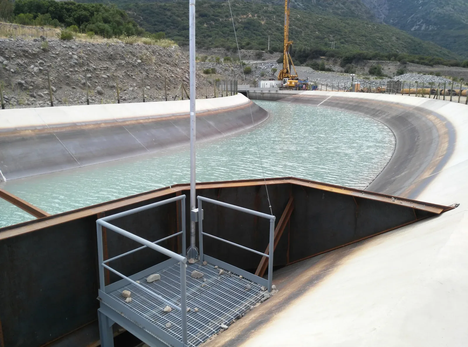 El canal ya con agua, con la compuerta y su pasarela de rejilla instaladas en la desembocadura